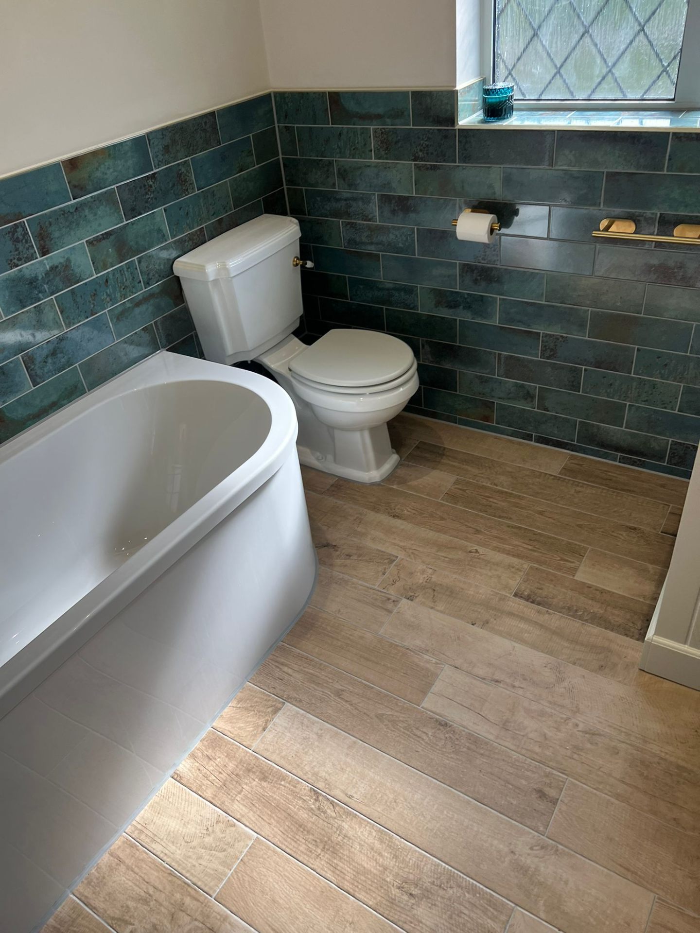 Luxury bathroom renovation with teal tiles and freestanding bath, Essex