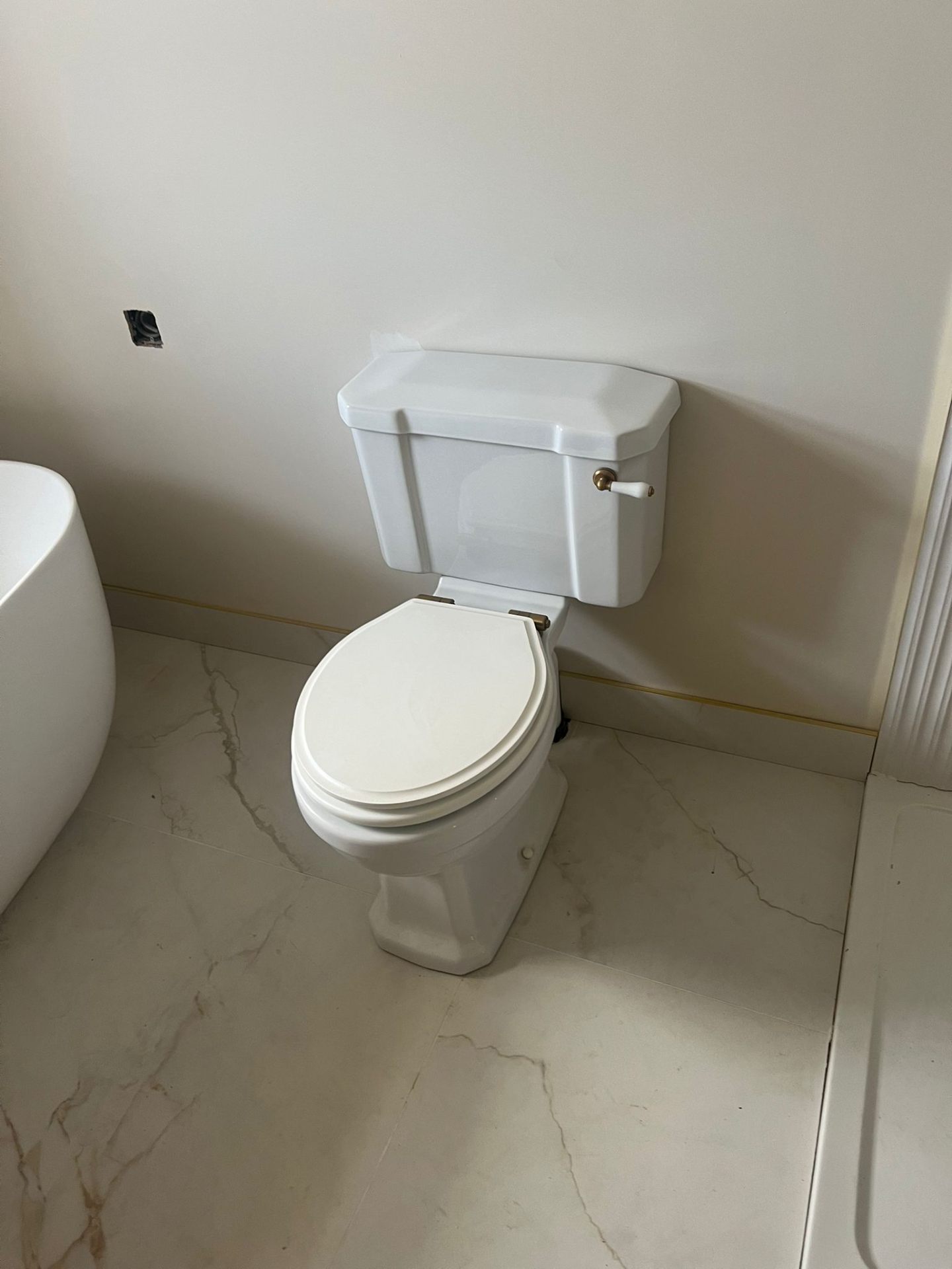 Bathroom toilet installation over marble floor tiles, Essex